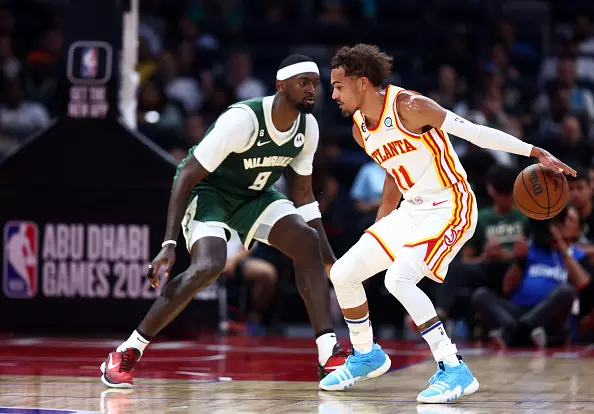 Trae Young build - Young attempting to dribble past Bobby Portis